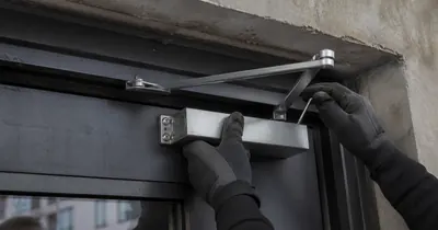Hands fit a lock on a commercial door.