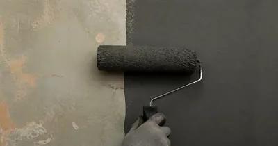 A roller paints a clean line on an interior wall.