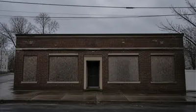 A quiet vacant property with boarded windows.